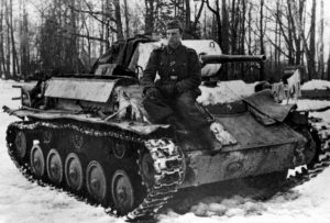 A German soldier poses on a knocked out T-70.