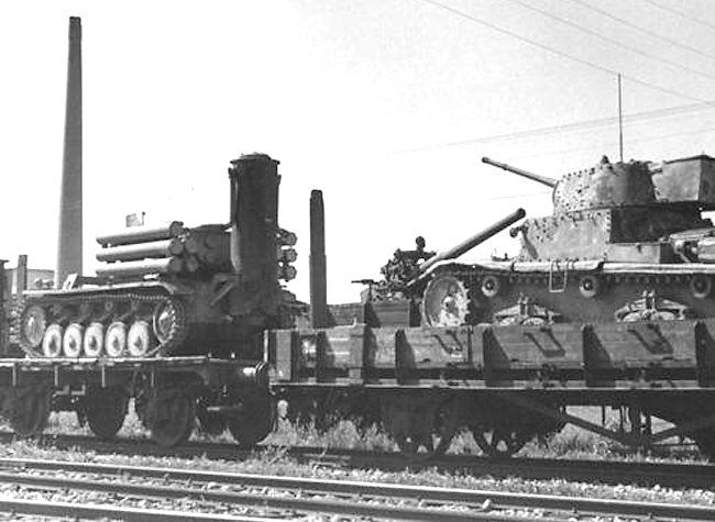 A Fahrschulepanzerwagen II being transported by rail, next to an Italian M15/42 with an added rear bustle.